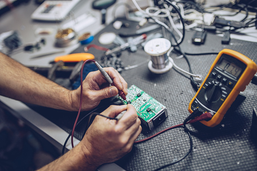 Electrician testing a circuit with a multimeter during an EICR inspection